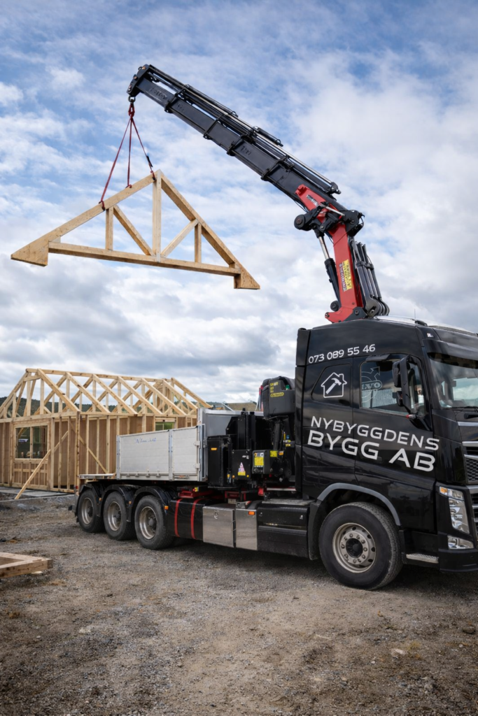 Kranbil i Älmhult som lyfter takstolar vid byggprojekt